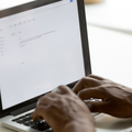 A person typing out an email on their laptop