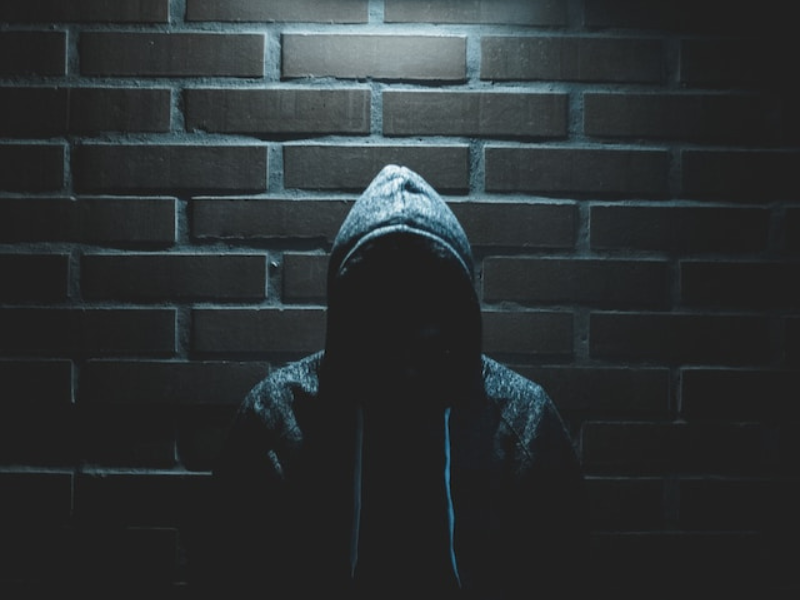 A person wearing a hoodie in the dark