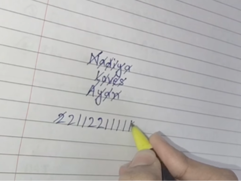 A person writing out a love test on a piece of paper