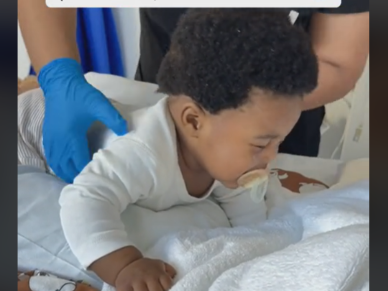A physiotherapist helps a baby with phlegm