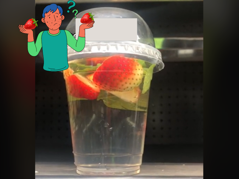 A plastic cup containing strawberries in a liquid
