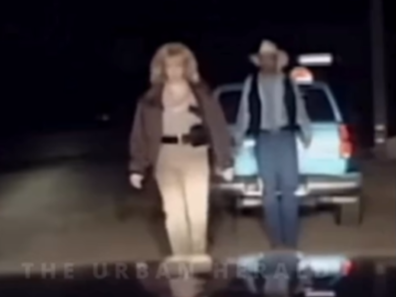 A police officer walks in front of a drunk driver