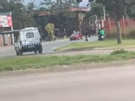 A police van tries to get an Uber Eats delivery driver to stop his bike