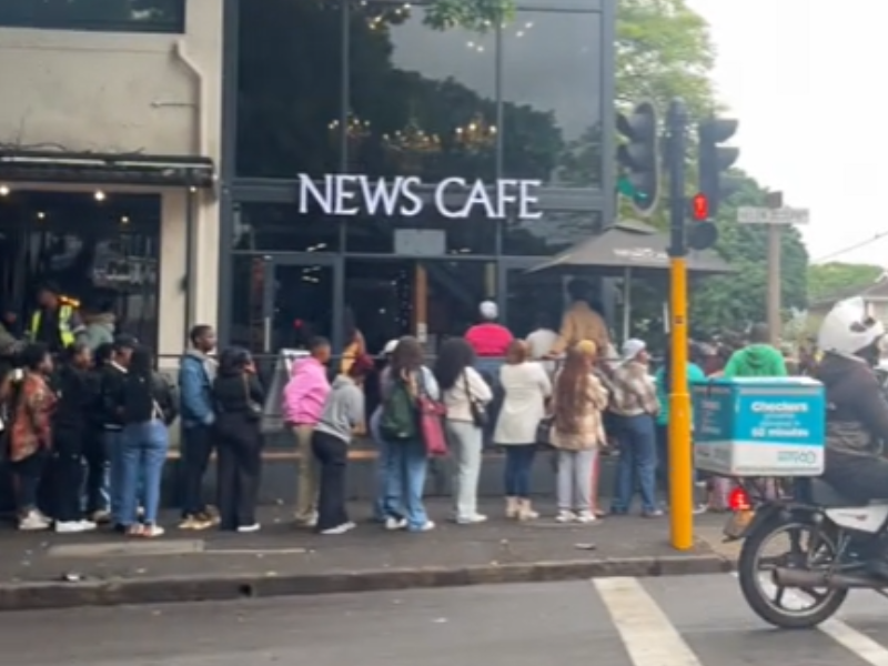 A queue of people line up on the roadside outside a Durban restaurant