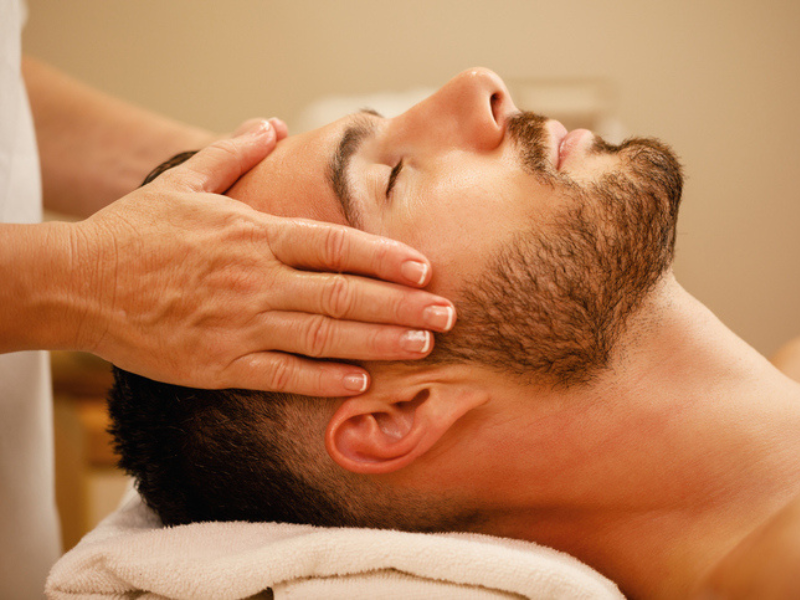 A relaxed man during a head massage at spa