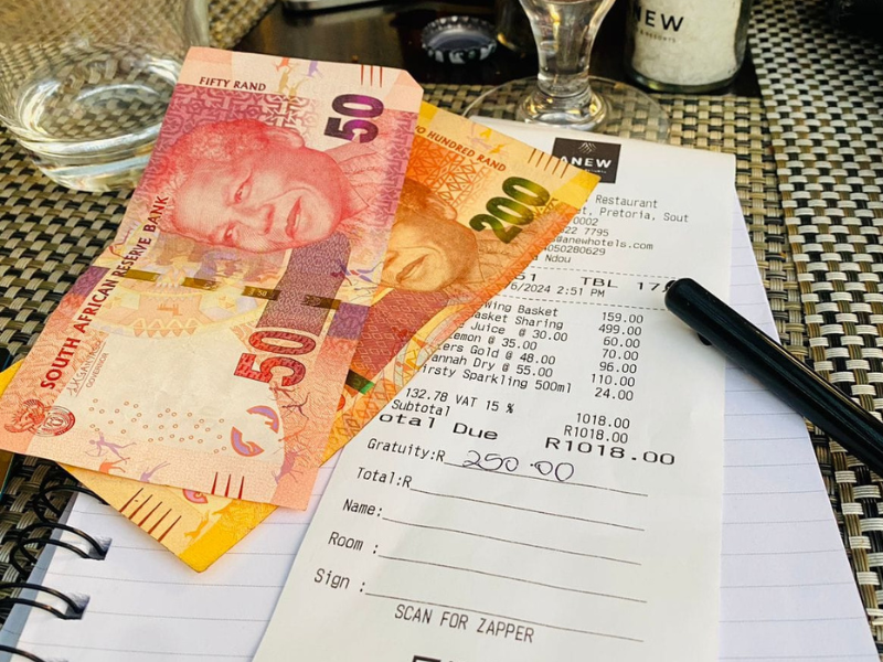 A restaurant bill with R250 South African Rand on top