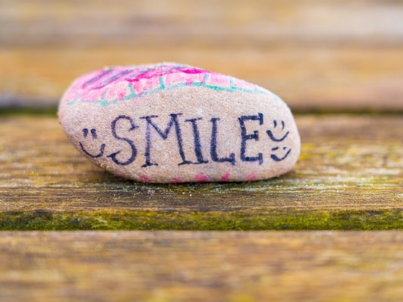 A rock with the world smile written on it