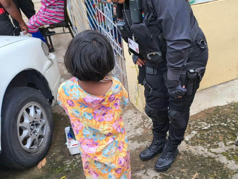 A security officer speaks to a young girl outside a home in Verulam