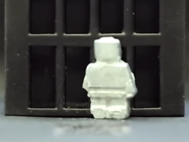 A shape shifting robot in front of a caged area