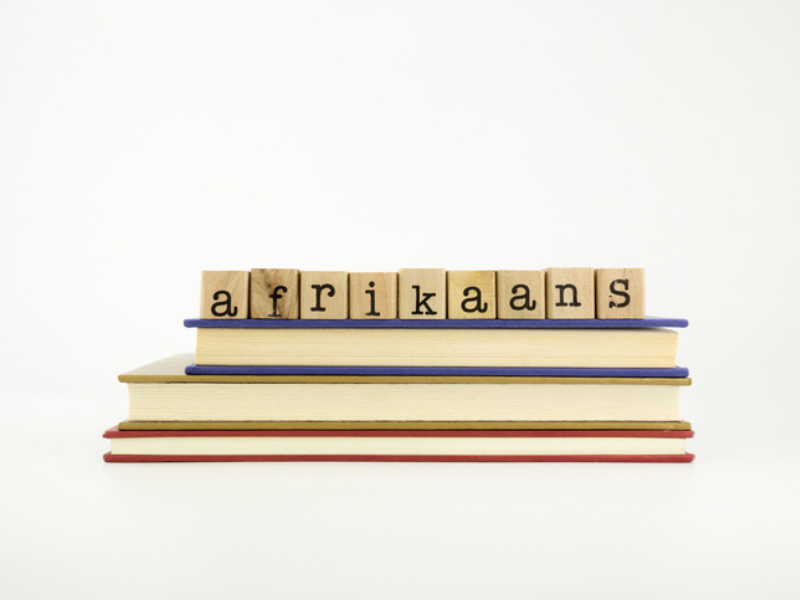 A stack of books with the word Afrikaans on wooden stamps