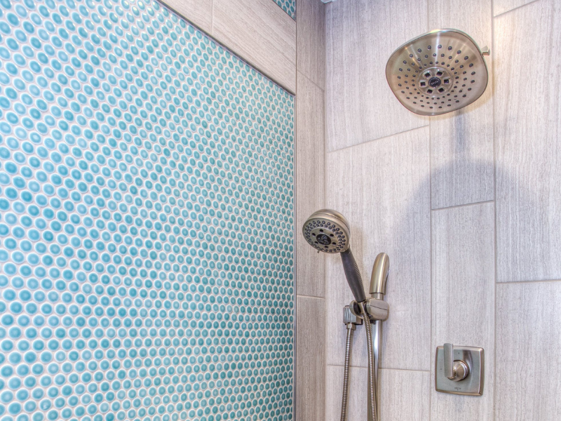 A stainless steel shower head inside bathroom