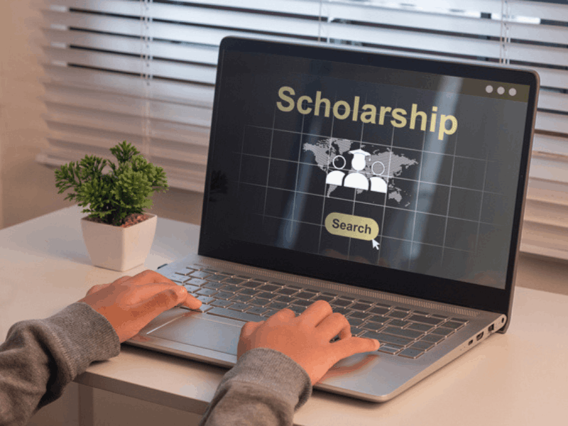 A student looking for scholarship on a laptop
