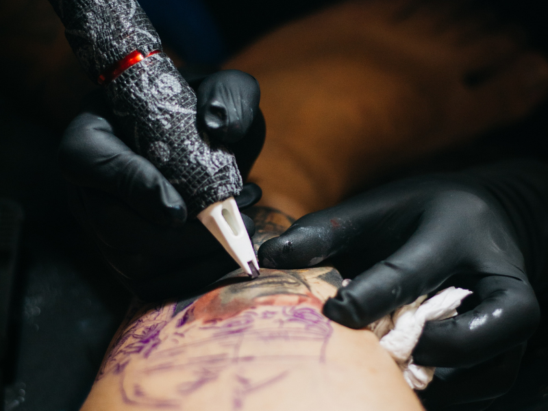 A tattoo artist tattooing someone