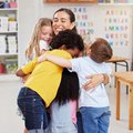 A teacher hugging her learners