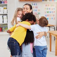 A teacher hugging her learners
