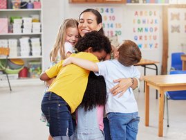 A teacher hugging her learners