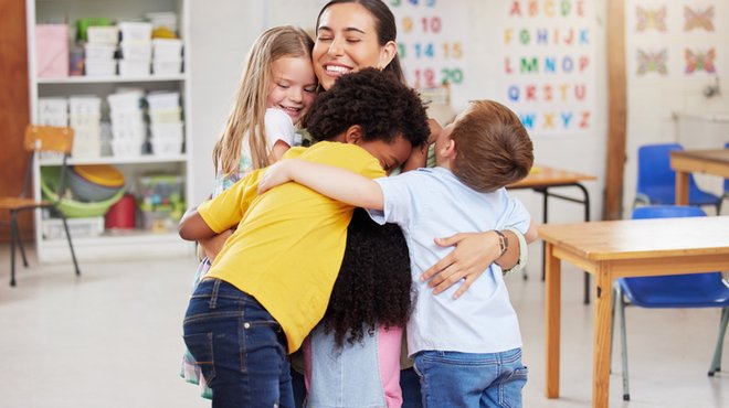 A teacher hugging her learners