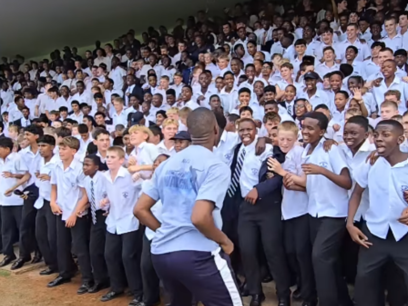 A teacher jumps with KZN school boys as they perform their war cry