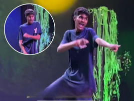 A teenage boy dances on stage at school talent show