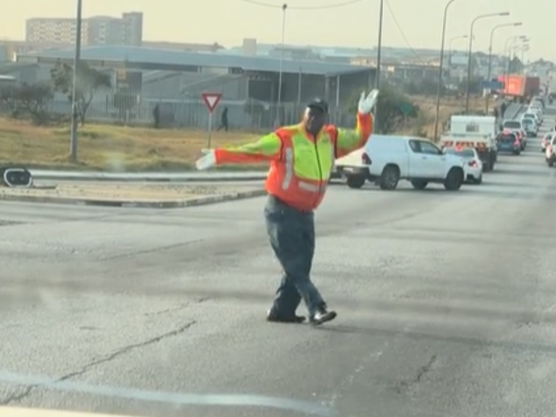 A traffic cop dances on the road while directing traffic