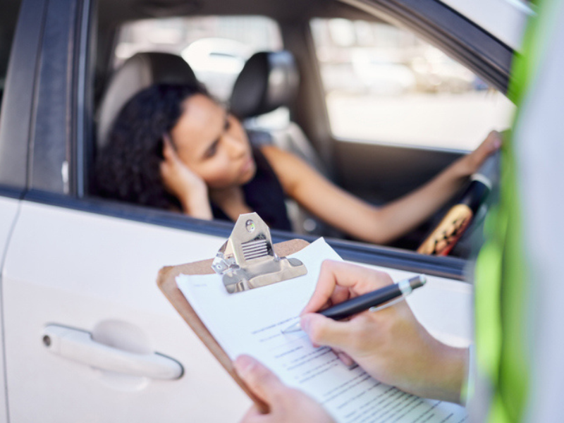 A traffic officer issuing a female driver a fine