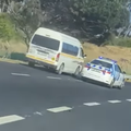 A traffic police car tries to stop a taxi