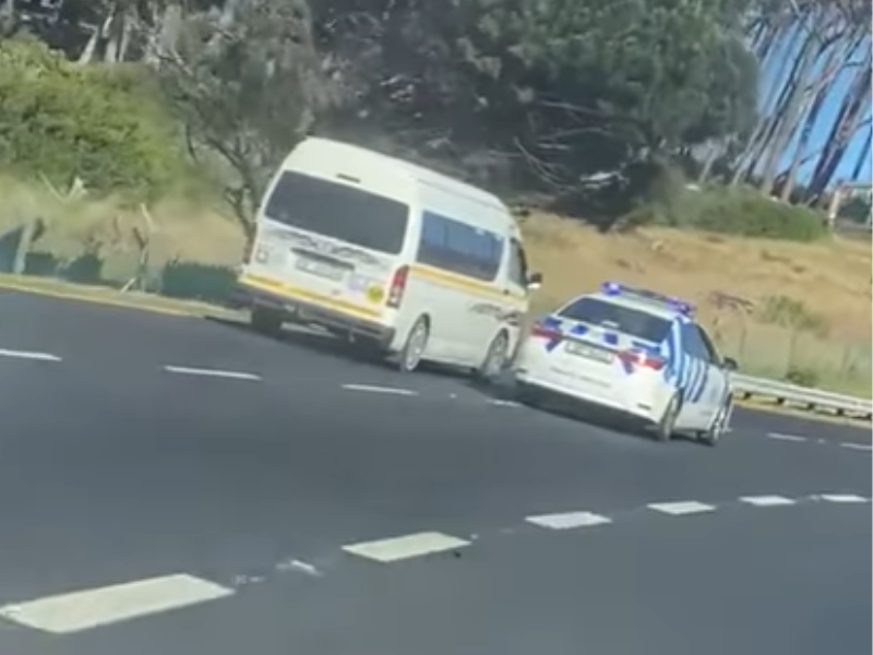 A traffic police car tries to stop a taxi