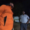 A traveler speaks with a South African police officer