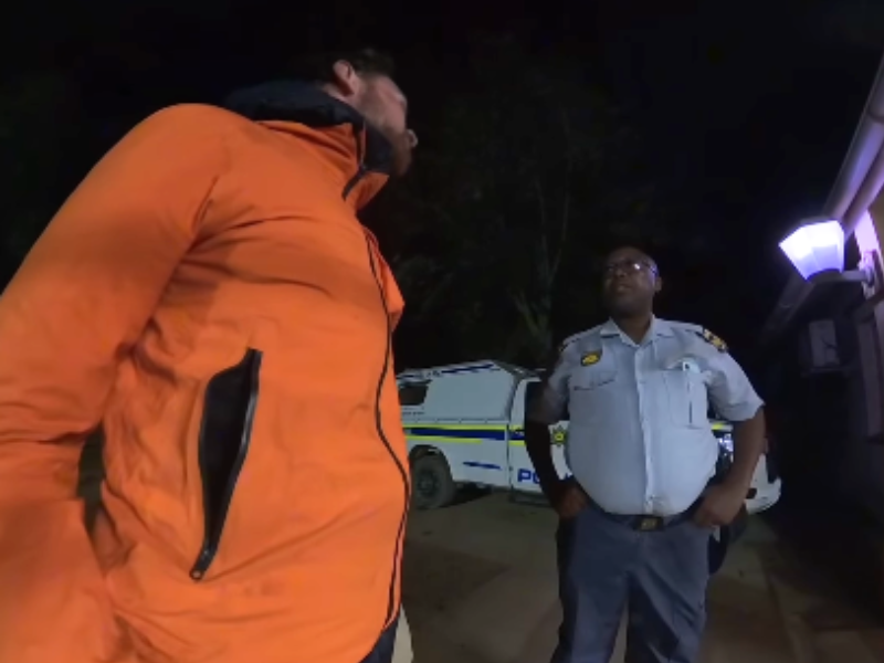 A traveler speaks with a South African police officer
