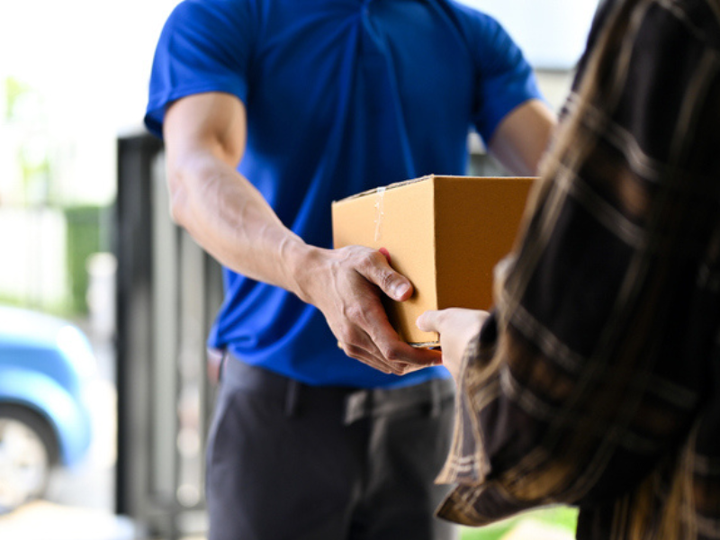 A view of a delivery man handing a parcel over to customer