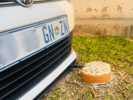 A white Volkswagen using hydraulics to cut a cake