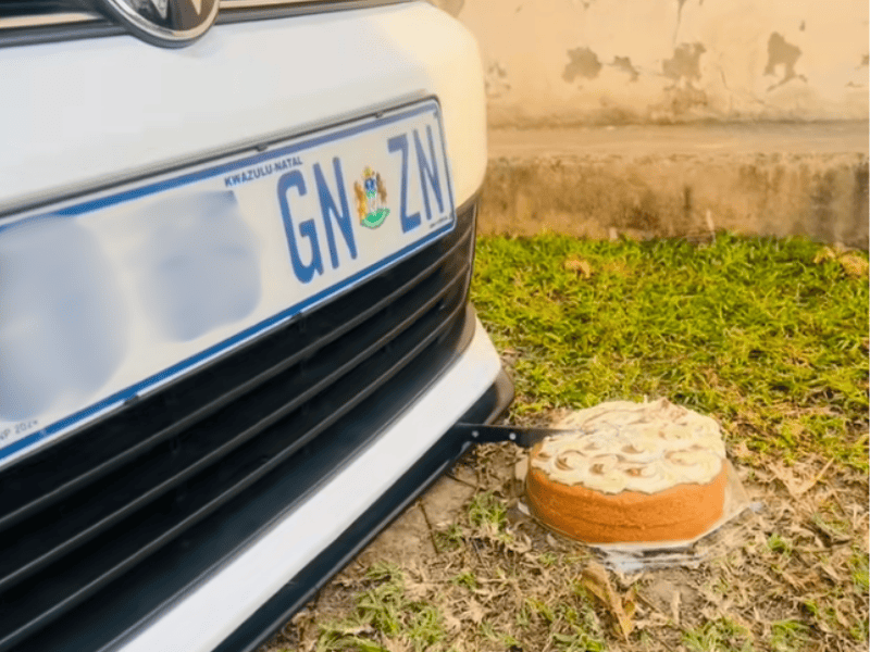 A white Volkswagen using hydraulics to cut a cake