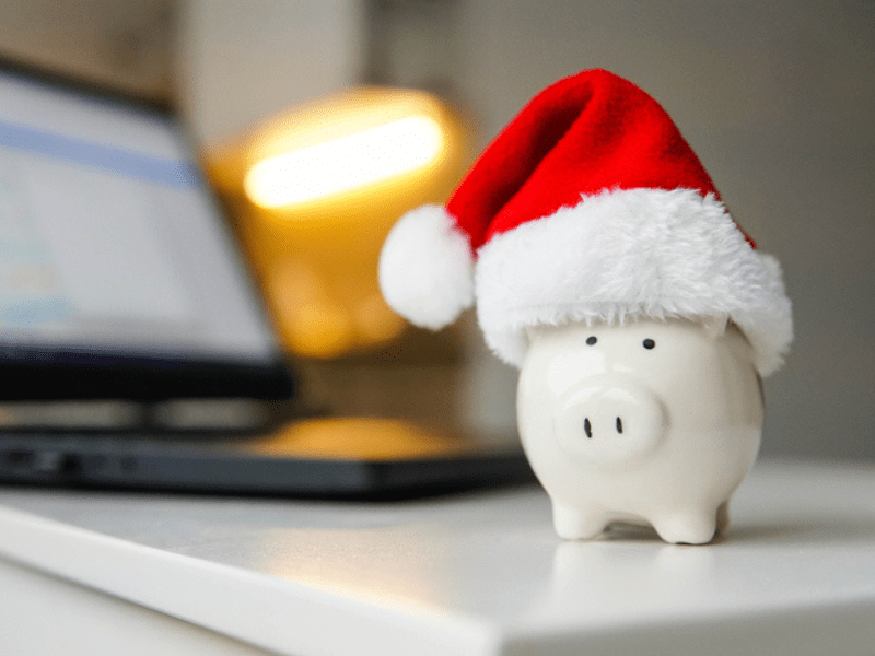 A white piggy bank with a red santa hat
