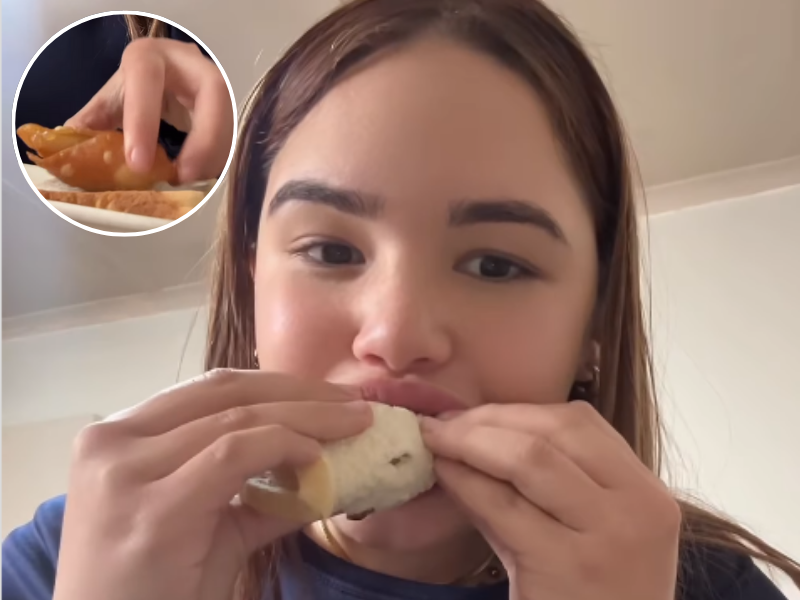 A woman biting into a sandwiched samoosa