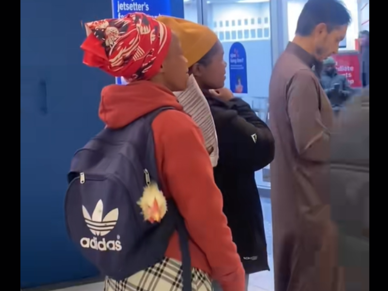A woman carries a chicken in her backpack outside a bank