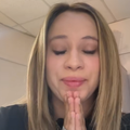 A woman closes her eyes and holds her palms together to say thank you