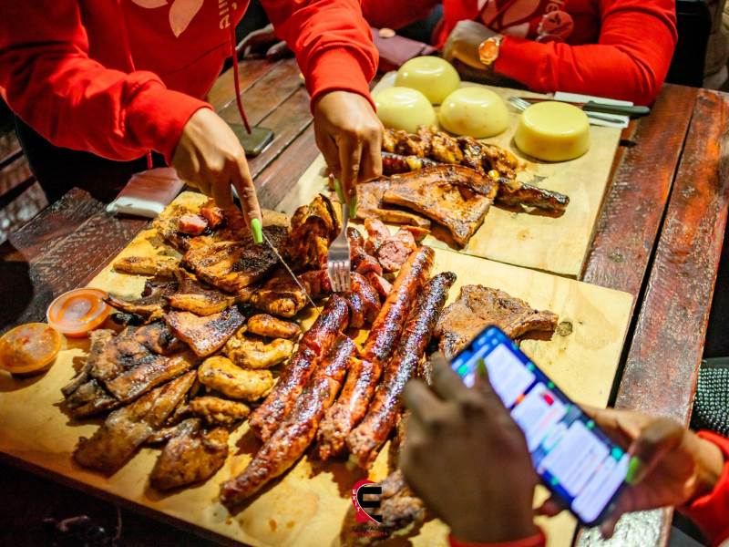 A woman cuts meat on a table at a Shisanyama spot in Umlazi