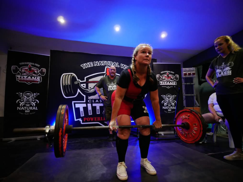 A woman doing a squat while lifting weights