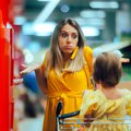 A woman grocery shopping explains frugality to her young daughter