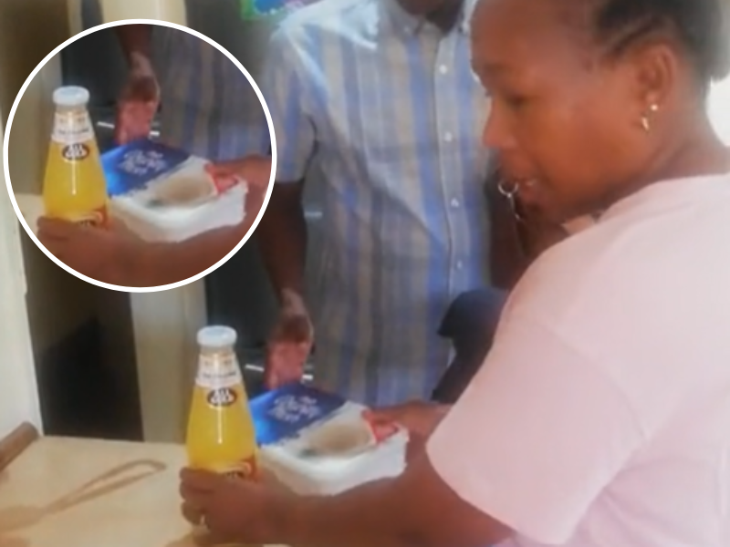 A woman hands her husband his lunch in an ice cream container