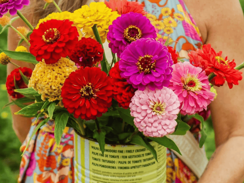 A woman holding a bunch of flowers inside a can