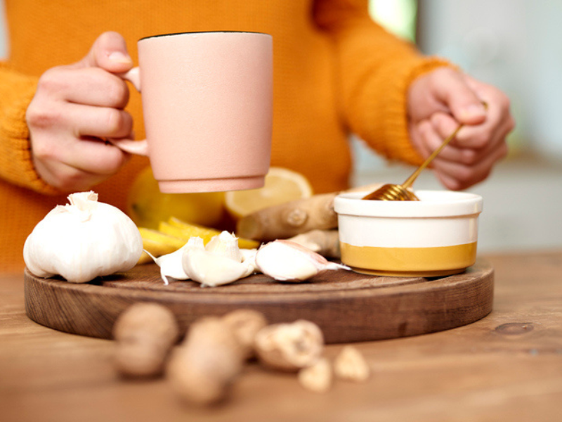 A woman holding a mug of warm water with honey