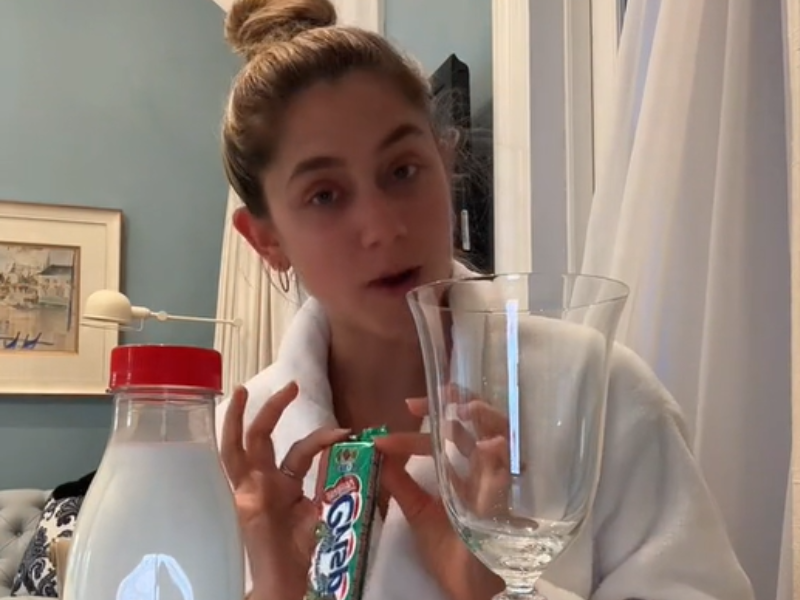 A woman holding a peppermint crisp chocolate bar in hotel room