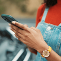 A woman holding her phone waiting for roadside assistance