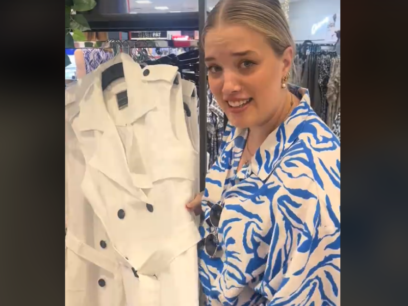 A woman holds a dress on the rack at a Woolworths store