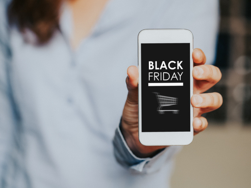 A woman holds a mobile phone with Black Friday shopping app on the screen