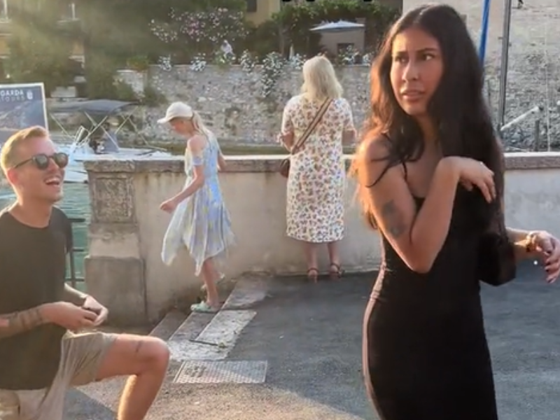 A woman pulls her hand away from boyfriend who goes down on one knee