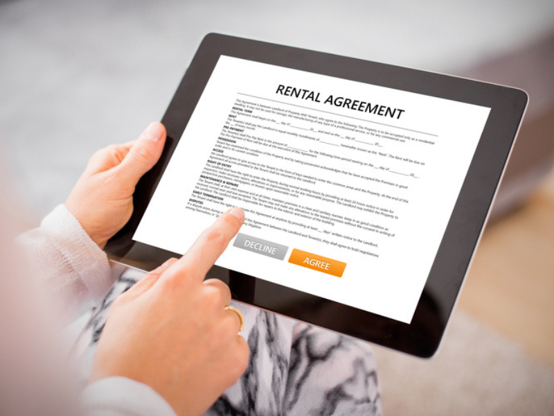 A woman reading a rental agreement on a tablet