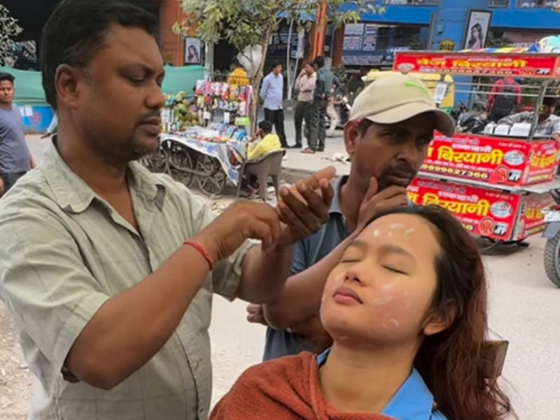 A woman receives a facial on the roadside in India