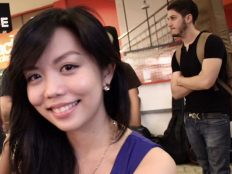 A woman seated with a man in the background